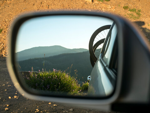 Bicycles on rack on back of car reflecting in side view mirror, McCall, Idaho, USA