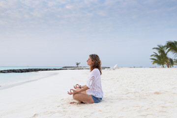 woman in meditation posture by the sea