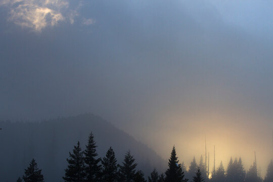 The sun sets through a foggy mist in the Wild and Scenic Lochsa River Valley , Idaho.