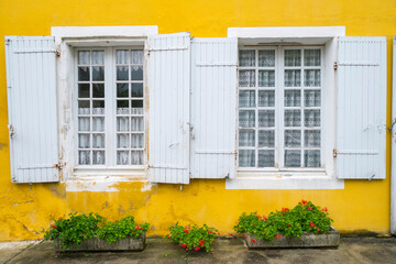 House with bright yellow wall and white windows with shutters, Monpazier, Dordogne department, Aquitaine, France