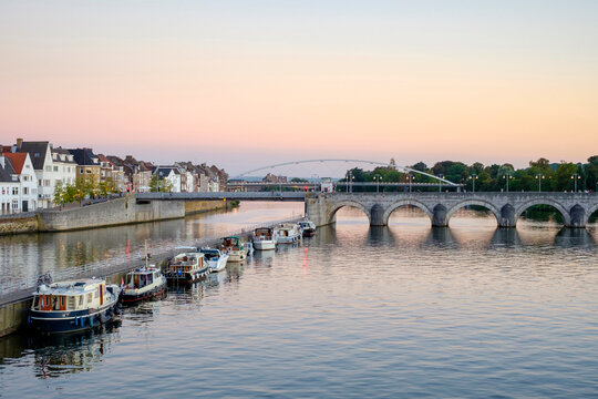 Meuse River with bridge, boats and buildings on bank, Maastricht, Limburg, Netherlands