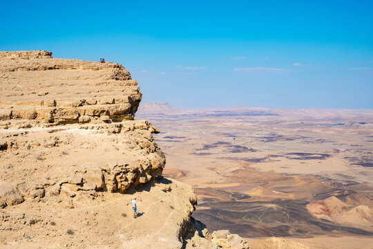 Hiker standing near edge of Makhtesh Ramon Crater, Negev Desert, Mitzpe Ramon, Southern District, Israel