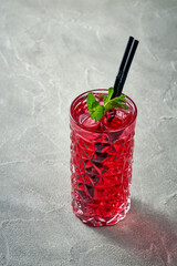 Alcoholic pink cocktail with cranberry and ice in a glass. Concrete background. Vermouth with vodka