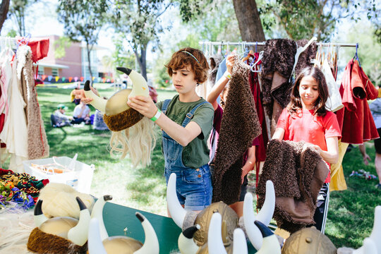 Young girls try on Viking clothes and helmets at Scandinavian festival