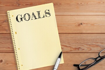 Open clean notebook with goals words on office desk