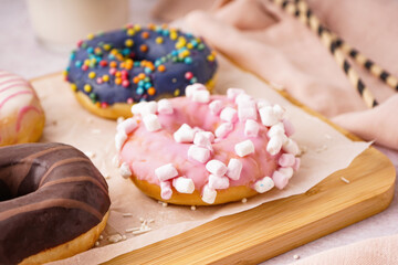 Board with different delicious donuts, closeup