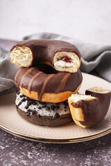 Plate with delicious chocolate donuts on grey table