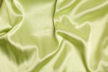 Smooth elegant light green silk or satin luxury fabric texture Top view.