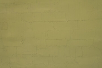 Texture of greenish yellow painted wall with cracks
