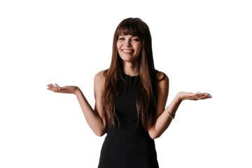 Playful brunette young woman in black dress standing at home against transparent background spreads hands in hesitate, toothy smiling looking at camera. Hispanic woman using hands like a clock hands.
