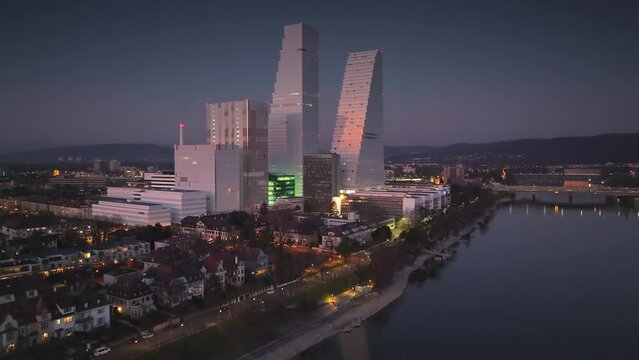 Drone panning shot of the ultramodern high-rise Roche Towers after sunset on a winter day in Basel Switzerland.