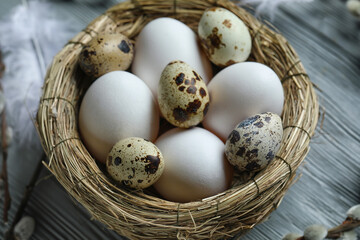 Nest of Easter eggs on grey wooden table, closeup