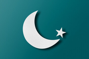 White paper cut into crescent shapes and stars set on green paper background.