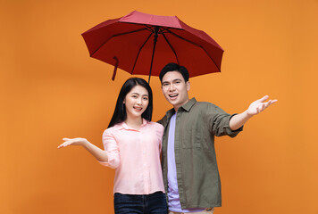 Young Asian couple with umbrella on background