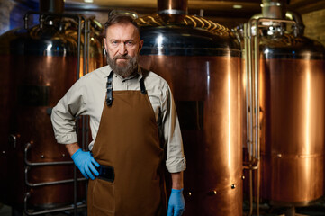 Fototapeta na wymiar Portrait of brewery owner wearing apron with arms crossed