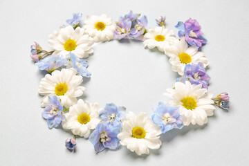 Frame made of beautiful chrysanthemum and delphinium flowers on grey background