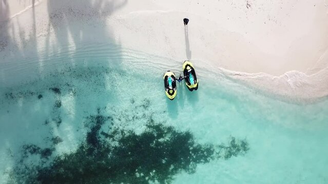 Aerial view of men and watercrafts at the beach. High quality 4k footage