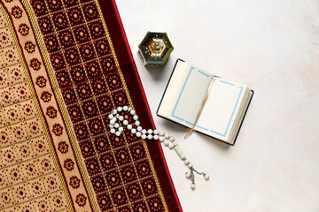 Koran with prayer beads, mat and lantern for Ramadan on white background