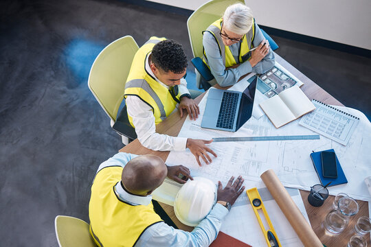 Architect, laptop and team in meeting above for construction or building planning strategy at office. Group of diverse engineers discussing floor plan, project layout or blueprints for architecture