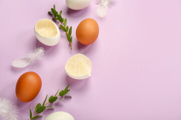 Composition with Easter eggs, feathers and eucalyptus branches on lilac background