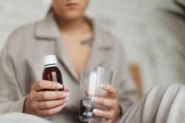 Close-up of woman with cancer taking pills, cancer awareness concept.