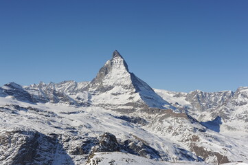 Matterhorn mountain peak  in Alps in winter with snow and clear blue sky in Cervinia, Italy and Zermatt, Switzerland. Beautiful and magnificent landscape on a sunny day