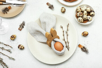 Table setting with Easter eggs, pussy willow branches and feathers on white background