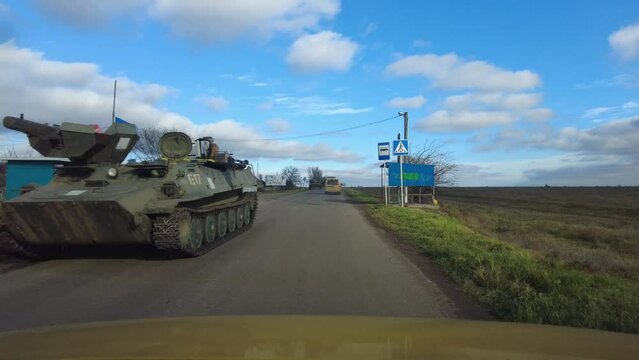 Heavy armored vehicles of the Ukrainian army are driving on the road.