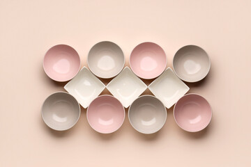 Set of different bowls on beige background