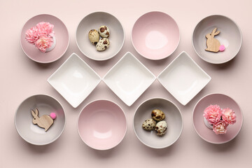 Set of different bowls with carnation flowers, Easter eggs and bunnies on beige background