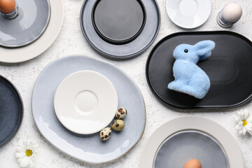 Set of plates with Easter eggs, bunny and chrysanthemum flowers on white grunge background