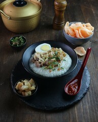 serving of chicken porridge with chicken and eggs on a rustic table