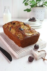 Banana and date cake ready to be cut on a wooden tray
