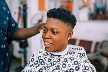 A young queer masculine woman getting a haircut