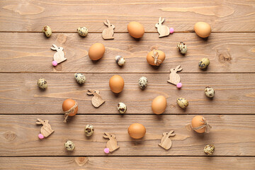 Composition with Easter eggs and bunnies on wooden background