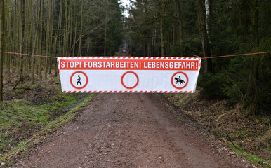 Stop! Forstarbeiten! Lebensgefahr! Absperrung an einem Waldweg.
