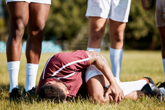 Knee pain, sports with injury and athlete outdoor, rugby and fitness with man, team and first aid. Medical emergency, wound and sport accident, training and exercise with help and injured person