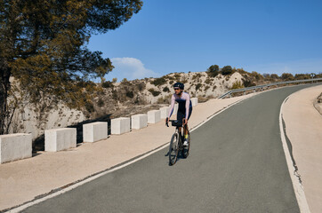 Obraz premium A male cyclist riding a gravel bike downhill on a mountain road.Beautiful motivation image of an athlete.