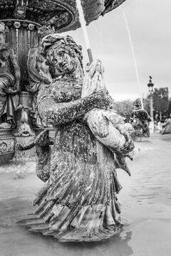 Close up on a naiad of a water fountain on the Place de la Concorde square in Paris, France in black and white