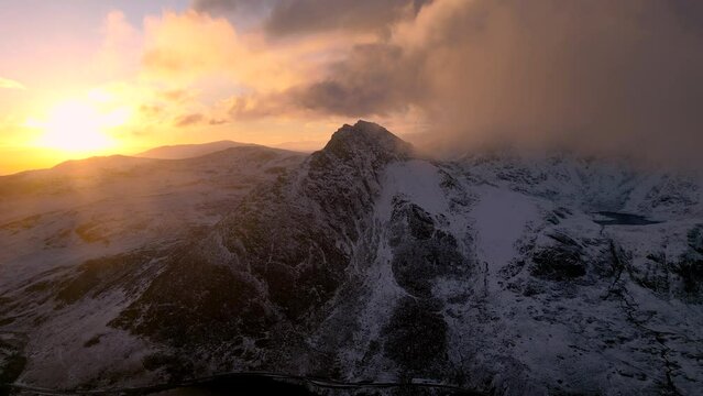 Aerial sunrise view of Tryfan in Snowdonia with low clouds and snow during winter