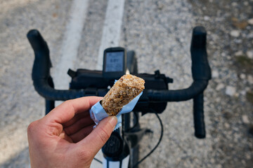 Sports snack for cyclist.A sports bar in the hand of a cyclist against the background of a...