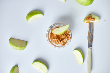 Green slices apples with peanut butter on white background, healthy snack, nutrition food, diet