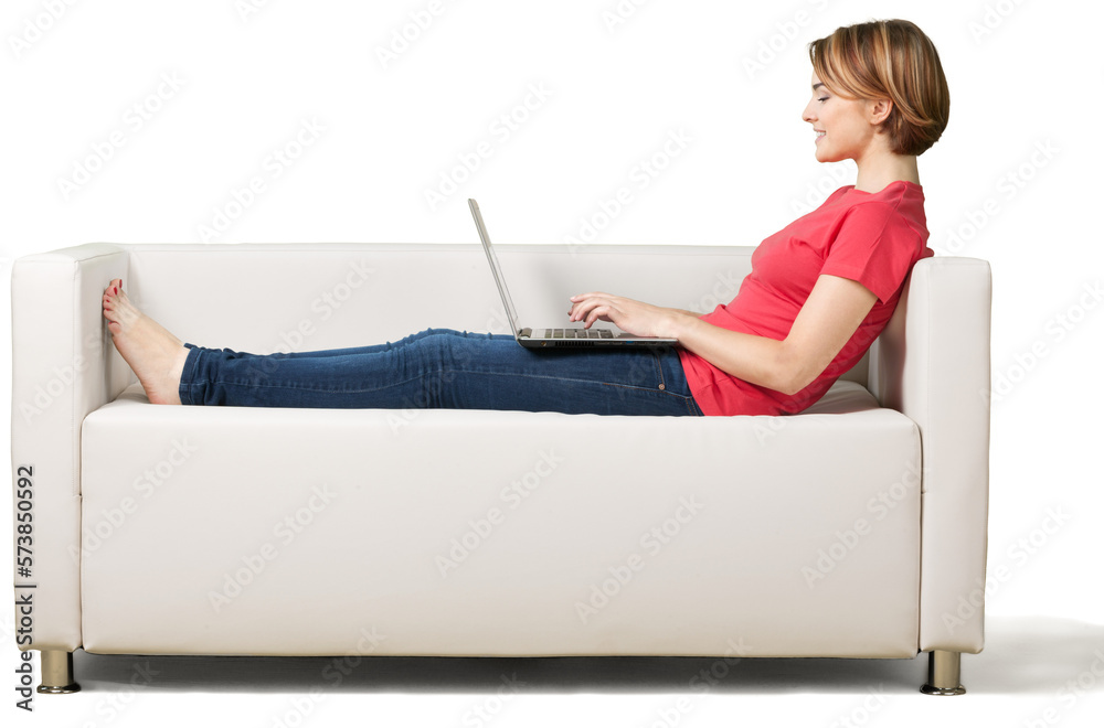 Wall mural young cute woman with laptop on sofa isolated on white background