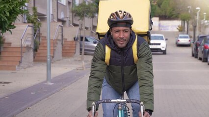 Black courier delivering food and drink in town outdoors on stylish bicycle in slow motion. Delivery man riding on bike with backpack. High quality 4k footage