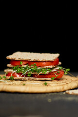 Healthy vegan sandwich with crisp rye bread tomatoe and microgreens