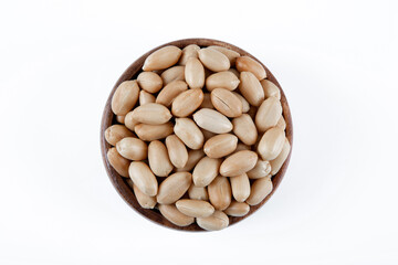 Bowl full of roasted peeled peanuts on white background

