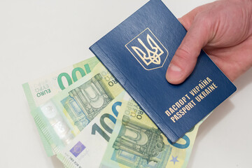 Passport of Ukraine and euro banknotes on a white background.