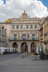 Obraz na płótnie Canvas View at the Cuenca City Hall, a Rococo building with big arches located on Plaza Mayor , Cuenca downtown, typical traditional colored architecture buildings around