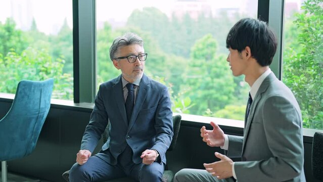 若いビジネスマンと握手するエグゼクティブ男性　スローモーション