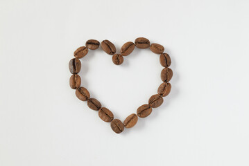 Roasted coffee beans as heart shape on white background